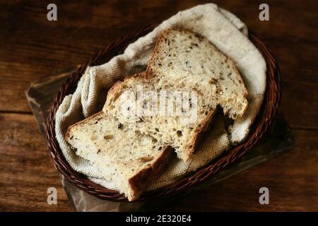 Des morceaux de pain tranchés sont dans un panier en osier sur une table en bois. Une pâtisserie maison de pain sans levure avec vos propres mains. Banque D'Images