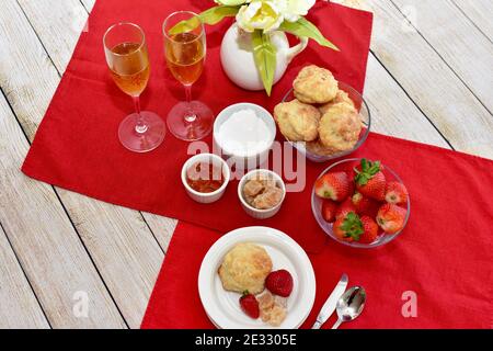 Petits gâteaux et fraises simples et élégants avec champagne pétillant pour le brunch de fête, le petit déjeuner de la fête des mères au lit ou le thé de printemps de l'après-midi de pâques Banque D'Images