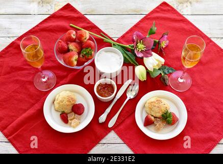 Petits gâteaux et fraises simples et élégants avec champagne pétillant pour le brunch de fête, le petit déjeuner de la fête des mères au lit ou le thé de printemps de l'après-midi de pâques Banque D'Images