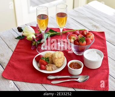 Petits gâteaux et fraises simples et élégants avec champagne pétillant pour le brunch de fête, le petit déjeuner de la fête des mères au lit ou le thé de printemps de l'après-midi de pâques Banque D'Images