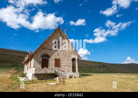 Petite maison de montagne typique en pierre dans un merveilleux paysage d'été dans le parc national des montagnes Sibillini, région des Marches, Italie Banque D'Images
