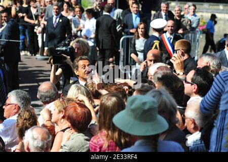 Le président français Nicolas Sarkozy et la première dame Carla Bruni-Sarkozy rencontrent les résidents et les touristes locaux lorsqu'ils arrivent pour une visite de la grotte de Lascaux, près du village de Montignac-sur-Vezere, dans le sud-ouest de la France, le 12 septembre 2010, dans le cadre du 70e anniversaire de la découverte de la grotte. La grotte de Lascaux est fermée au public depuis 1963 pour empêcher la détérioration des peintures causée par l'humidité et la chaleur des visiteurs. Un centre d'accueil, qui accueille environ 300,000 touristes chaque année, a été construit à l'extérieur de la grotte, avec des répliques des chambres peintes. Photo de Christophe Banque D'Images