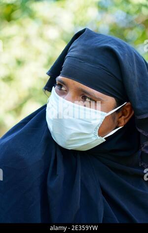 Un tir vertical d'une femelle dans hijab portant un masque facial Banque D'Images