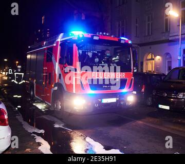 Berlin, Allemagne. 17 janvier 2021. Un pompier marche à côté d'un véhicule d'urgence. Dans la rue, on peut toujours voir de la mousse et de l'eau provenant de l'opération. Dans la Muthesiusstraße à Steglitz, un incendie a éclaté dans l'arrière-cour du 1er étage pour des raisons encore inexpliquées. Le feu s'est propagé au 2ème étage. Le service des incendies était sur les lieux avec environ 60 pompiers. (À dpa: 'Incendie dans un immeuble d'appartements à Berlin - une personne remise en service') Credit: Annette Riedl/dpa/Alay Live News Banque D'Images