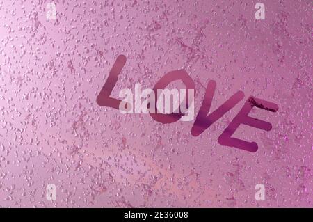 Image 3D , écrit '' l'amour 'sur la vitre de fenêtre avec des gouttes sur fond rose. Concept Saint Valentin, mariage Banque D'Images