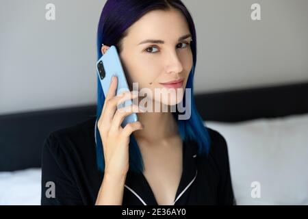 Les femmes avec des cheveux bleus dans la chambre parle sur le téléphone portable Banque D'Images