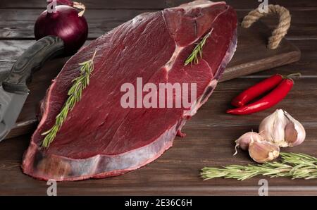 morceau de viande fraîche crue sur fond de bois. viande et épices. Banque D'Images