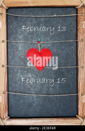 Concept de jour de Valentines en cadre en bois sur fond noir coeur rouge icône accrochée sur la corde à linge, espace de copie, espace pour le texte Banque D'Images