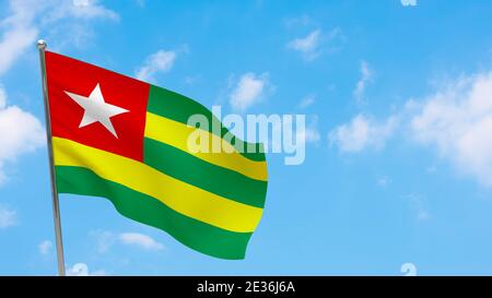 Drapeau du Togo sur la perche. Ciel bleu. Drapeau national du Togo Banque D'Images