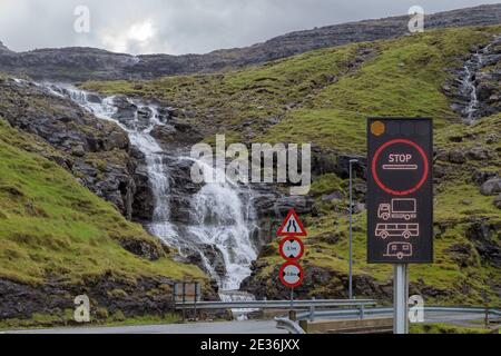 Cascade et panneaux routiers pour l'entrée du tunnel de Klaksvik, îles Féroé Banque D'Images