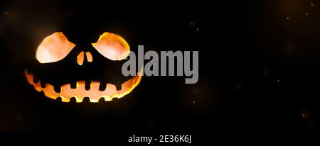 Concept d'halloween à la citrouille lumineuse sur fond sombre Banque D'Images