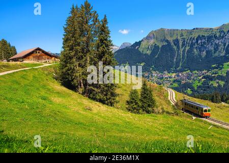 Voyage d'été incroyable, train touristique électrique rouge populaire sur le chemin de fer de montagne spectaculaire, près de la gare de Murren, Oberl Bernese Banque D'Images