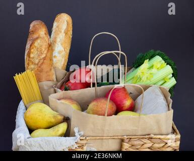 Légumes, légumes verts et fruits écologiques frais, céréales et pâtes dans un panier en osier. Livraison ou don de concept écologique de nourriture agricole Banque D'Images