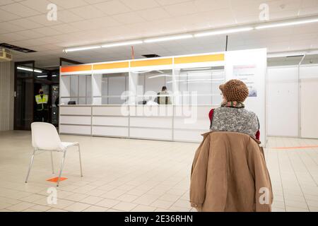 Pirna, Allemagne. 12 janvier 2021. Une femme est assise sur une chaise dans la salle d'attente. Le centre de vaccination du district de Sächsische Schweiz-Osterzgebirge est situé dans l'ancien magasin discount Aldi. Ici, les personnes âgées et du système de santé du district seront vaccinées à partir de 11.01.2021. Credit: Daniel Schäfer/dpa-Zentralbild/dpa/Alay Live News Banque D'Images