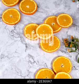 Tranches d'orange frais joliment disposées sur une table en marbre blanc Banque D'Images