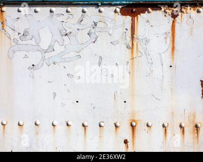 Peinture écaillée blanche texture rouille grunge fond d'un panneau texturé en fonte d'époque peint en blanc avec rivets en métal, photo d'image Banque D'Images