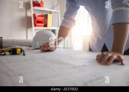 Architecte travaillant au bureau avec des plans, ingénieur de réflexion et de planification d'inspection sur le lieu de travail pour le plan architectural, esquisser un pro de construction Banque D'Images