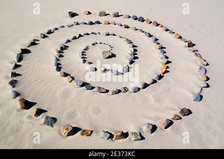 Spirale de pierres sur la plage de sable Banque D'Images