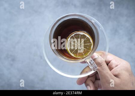 tenir à la main une tasse de thé au citron avec un espace de copie Banque D'Images