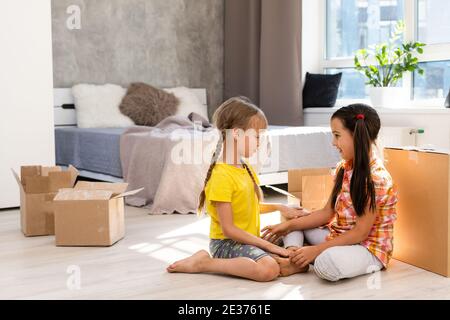 Excitée drôle enfants filles courir dans le luxe grande maison moderne le jour de déménagement, les enfants mignons entrant explorer la nouvelle maison, heureux jeune famille acheter Banque D'Images