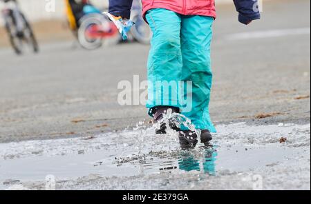 Berlin, Allemagne. 17 janvier 2021. Une fille joue à une flaque à moitié gelée sur Tempelhofer Feld. Dimanche, les températures dans la capitale sont autour du point de congélation. Credit: Annette Riedl/dpa/Alay Live News Banque D'Images