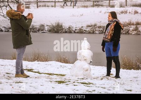 Duelmen, NRW, Allemagne. 17 janvier 2021. Un couple prend des photos avec son bonhomme de neige. Une couche de neige fraîche est tombée la nuit, transformant la campagne du Muensterland en un pays merveilleux pour l'hiver pendant quelques jours. Credit: Imagetraceur/Alamy Live News Banque D'Images