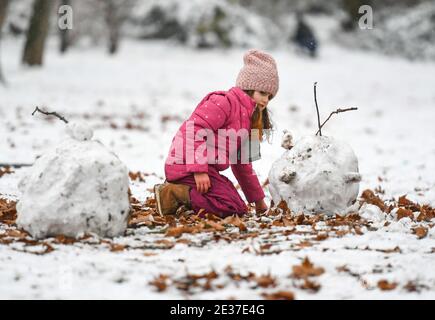 Francfort, Allemagne. 17 janvier 2021. Un enfant joue avec de la neige dans un parc couvert de neige à Francfort, en Allemagne, le 17 janvier 2021. Une chute de neige a frappé Francfort dimanche. Crédit: Lu Yang/Xinhua/Alay Live News Banque D'Images