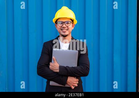 Portrait d'Asian Business homme d'importation et d'exportation des marchandises porter un casque logitics expédition à l'arrière-plan du conteneur. Banque D'Images