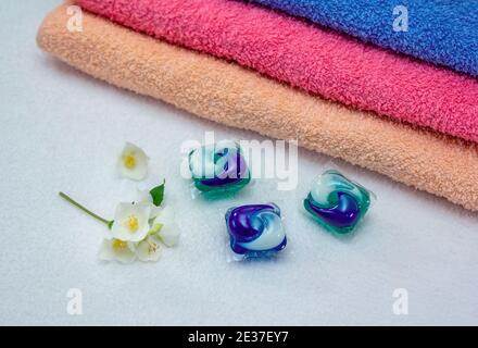 Dosettes de lessive pour lave-linge et serviettes de bain colorées. Capsule de gel écologique trois en une. Banque D'Images