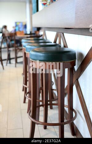 Tabourets de bar en bois dans un restaurant le jour Banque D'Images