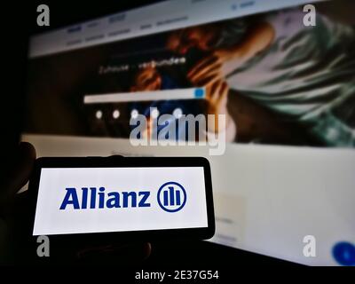 Titulaire d'un smartphone portant le logo de la société allemande de services financiers Allianz se (assurance et gestion d'actifs). Mise au point sur l'écran du téléphone mobile. Banque D'Images