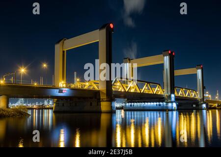Pont Botlek la nuit. Un pont élévateur vertical moderne au-dessus de la rivière Oude Maas (la vieille Meuse) près de Rotterdam, pays-Bas. L'autoroute A15 et une railwa Banque D'Images