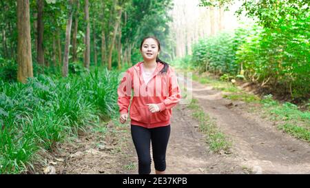 Femme asiatique en forêt vêtue d'une veste Banque D'Images