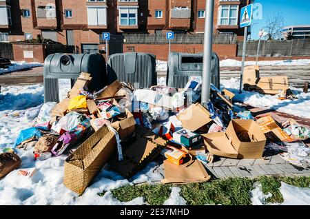 Madrid, Espagne - le 17 janvier 2021 : une semaine après la tempête d'hiver Filomena, les ordures sont entassées dans les rues de Madrid, Espagne. Les camions à ordures sont incapables de faire des collectes après la tempête et les déchets restent entassés dans toute la ville, débordant les poubelles publiques et domestiques Banque D'Images