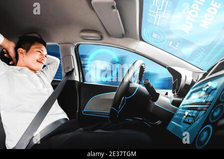 Voiture autonome avec un jeune homme détendu assis au siège du conducteur conduit sur la route très fréquentée de la ville. Concept d'apprentissage machine Banque D'Images