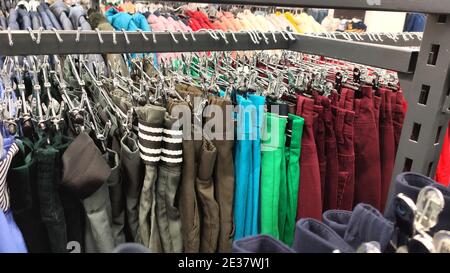 Une rangée de pantalons colorés différents sur cintre dans la boutique, Banque D'Images