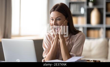 Gros plan surjoyeuse femme surprise regardant l'écran d'ordinateur portable Banque D'Images