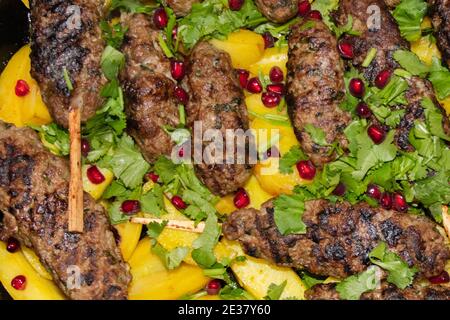 Boulettes de viande grillées aux pommes de terre et aux herbes dans un plat de cuisson. Pose à plat Banque D'Images