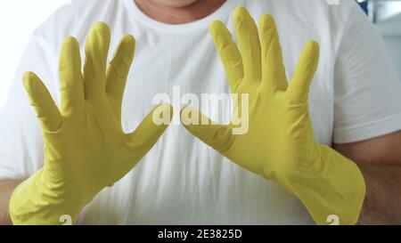 Image en gros plan avec les mains de la femme de ménage portant des gants de protection jaunes pour la maison Utilisé pour le nettoyage de la cuisine Banque D'Images