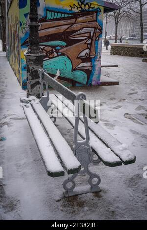 Paris, France - 01 16 2021 : banc public au bassin de la villette sous la neige Banque D'Images