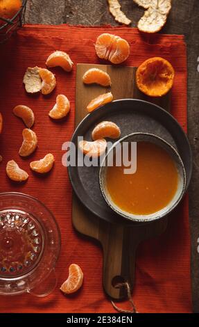 Jus de mandarine fraîchement pressé en verre sur fond de bois rustique Banque D'Images