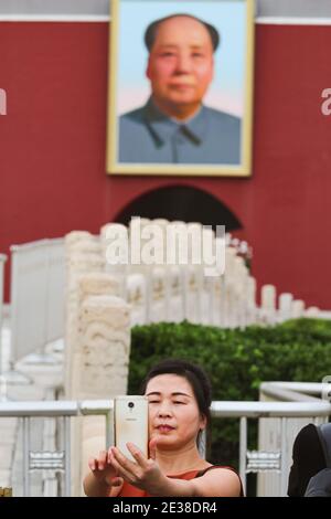 BEIJING, CHINE - 26 AOÛT 2017; une femme plus âgée pose pour une photographie de selfie sur la place Tian an Men devant la porte de la paix céleste (entrée Banque D'Images