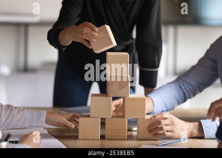 Gros plan de l'équipe des employés jouant avec des cubes en bois, la construction d'équipe Banque D'Images