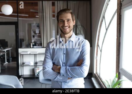 Portrait en tête souriant homme d'affaires réussi debout dans un bureau moderne Banque D'Images