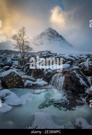 La rivière Frozen Coupall passe le long de Stob Dearg (le sommet le plus important de Buachille Etive More) lors d'une journée hivernale à Glencoe, en Écosse, au Royaume-Uni. Banque D'Images