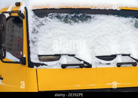 Neige sur le pare-brise d'un camion jaune Banque D'Images