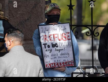 Austin, TX USA 17 janvier 2021 : un manifestant seul au Texas Capitol tient un panneau pour l'unité au milieu de dizaines de milices texanes lourdement armées qui se ralliaient à proximité lors d'un spectacle de force qui a précédé l'inauguration du président Joe Biden mercredi. La plupart des hommes portant des armes ont plaidé en faveur de leur droit en vertu du deuxième amendement à la Constitution des États-Unis, pas nécessairement en faveur du président sortant Donald Trump. Crédit : Bob Daemmrich/Alay Live News Banque D'Images