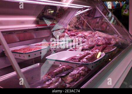 Foyer sélectif et vue de face du rouge frais cru bonne qualité de la viande à travers le verre du comptoir à la boucherie. Banque D'Images