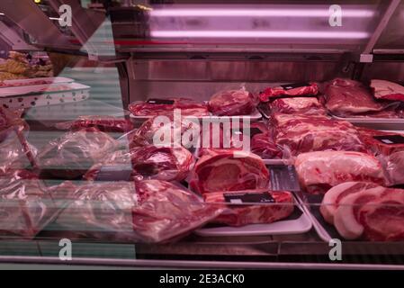 Foyer sélectif et vue de face du rouge frais cru bonne qualité de la viande à travers le verre du comptoir à la boucherie. Banque D'Images