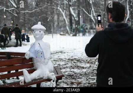 Francfort, Allemagne. 17 janvier 2021. Un homme prend des photos d'un bonhomme de neige tenant un papier portant la mention « Stay Healthy » dans un parc de Francfort, en Allemagne, le 17 janvier 2021. Crédit: Lu Yang/Xinhua/Alay Live News Banque D'Images